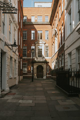 Fototapeta na wymiar Classic english architecture in an interior court with building door entrances and windows, with daylight, in London city center, United Kingdom.