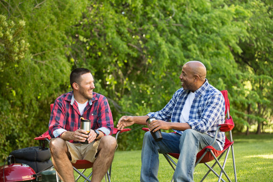 Multi-Ethnic Group Of Friends Talking And Camping.