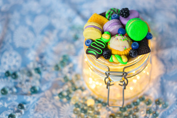Стеклянная баночка с гирляндой внутри с декором из полимерной глины в виде  разноцветных сладостей: пирожных макарун, печенья, ягод черники и ежевики, конфеты и леденца