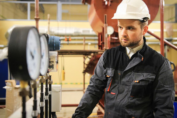 Worker monitors level of pressure on manometers