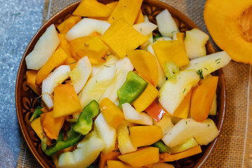 Fresh vegetables (squash, pumpkin, tomatoes, pepper..) cut for cooking. Vegetarian dish.