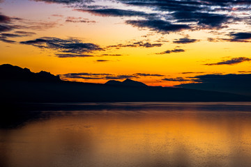 Fototapeta na wymiar Beautiful colorful sunset in the autumn above the French Alps and Lake Geneva where the colors and clouds reflect beautifully.