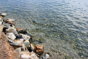 Sea water surface with shoreline rocks texture ripples beach