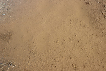 Muddy puddle on beige brown dirt road abstract horizontal