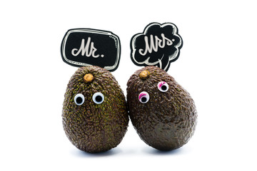 Romantic avocados couple with googly eyes and speech bubbles with text Mr and Mrs, funny food and love concept for creative projects