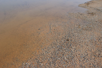 Muddy puddle on beige brown dirt road abstract horizontal