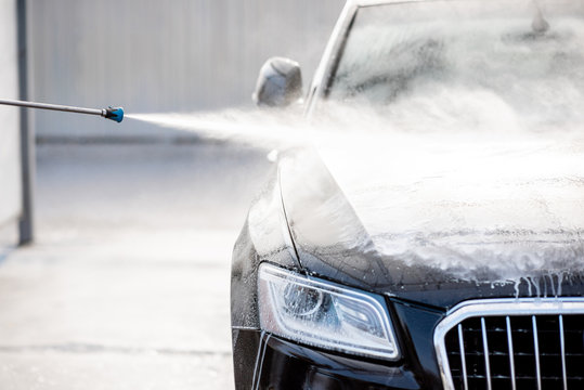 Close-up of a car under the water jet during the washing process on a self service car wash