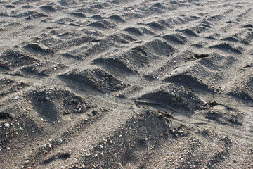 Tire tyre tracks on beach sand surface texture horizontal detail abstract