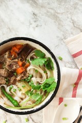 Pho Vietnamse Noodle Soup in a bowl overhead view with copy space
