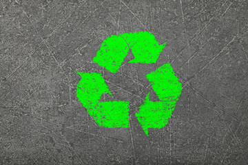 Grunge concrete background with green recycling logo sign