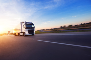 Loaded European truck on motorway in sunset - obrazy, fototapety, plakaty