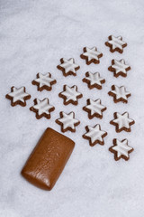 cinnamon stars and gingerbread laying on snow and form a fir tree