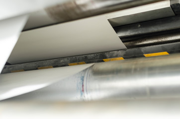 Closeup of printng machine working with roll paper for magazine production