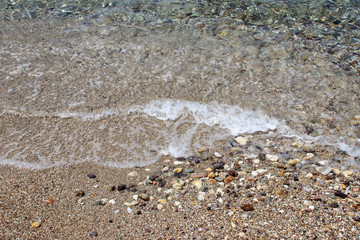 Water sea ocean sand pebbles beach swash wave waterline shallow surface texture clear summer nobody abstract background