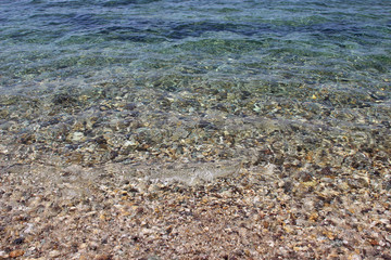 Water sea ocean sand pebbles beach swash wave waterline shallow surface texture clear summer nobody abstract background