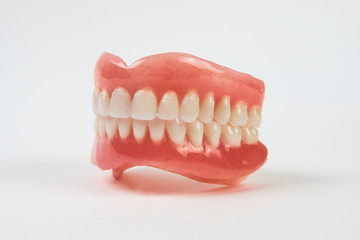 Artificial teeth on a white background with copy space.