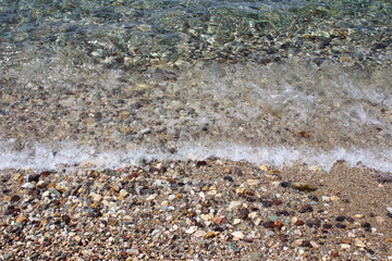 Water sea ocean sand pebbles beach swash wave waterline shallow surface texture clear summer nobody abstract background