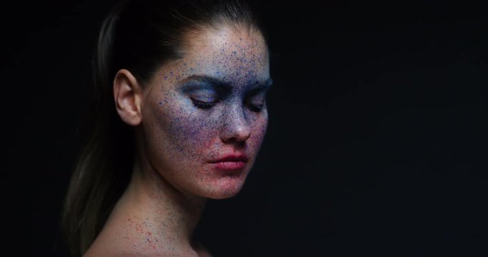 portrait beautiful woman wearing blue face paint makeup looking up exotic body art on attractive female performer creative expression light fading in dark background