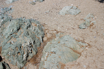 Rocks boulders on beach shore sand grey gray sedimentary detail abstract