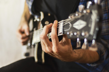 Playing an electric guitar close-up