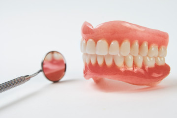 Artificial teeth on a white background with copy space.