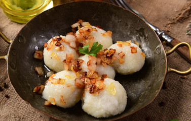 Meat stuffed potato dumplings with fried onion and greaves on top