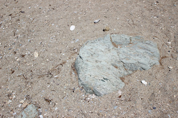 Rocks boulders on beach shore sand grey gray sedimentary detail abstract