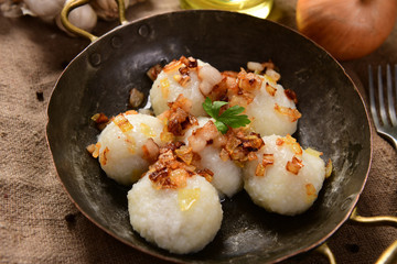 Meat stuffed potato dumplings with fried onion and greaves on top