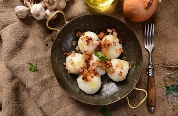 Meat stuffed potato dumplings with fried onion and greaves on top