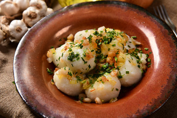 Meat stuffed potato dumplings with fried onion and greaves on top