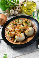 Meat stuffed potato dumplings with fried onion and greaves on top
