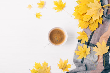 Flat lay cup of coffee among side composition of autumn leaves