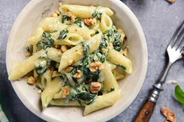 Penne pasta with spinach, gorgonzola cheese and walnuts