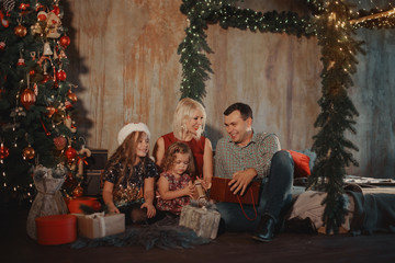 Obraz na płótnie Canvas Christmas Family Open Present Gift Bag, Looking to Magic Light in Night Xmas Tree loft Interior
