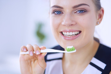 Young pretty girl maintaining oral hygiene with toothbrush.