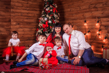 A large family gathered around the New Year tree. Merry Christmas and Happy New Year. parents and children.