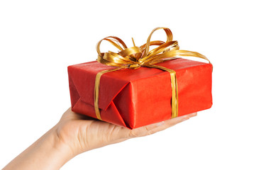 Red christmas present with golden bow in woman hands
