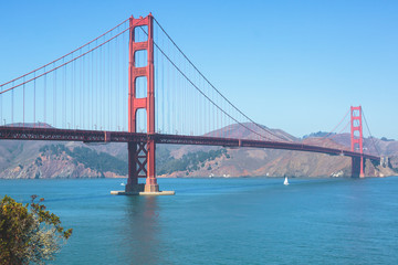Classic panoramic view of famous Golden Gate Bridge seen from Baker Beach in beautiful summer sunny day with blue sky, San Francisco, California, USA