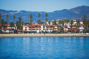 Beautiful view of Santa Barbara ocean front walk, with beach and marina, palms and mountains, Santa Ynez mountains and Pacific Ocean, Santa Barbara county, California, United States, summer sunny day - obrazy, fototapety, plakaty