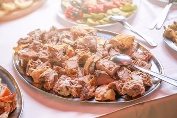 Delicious pieces of pork meat on large plate. Large plate with meat on a wedding