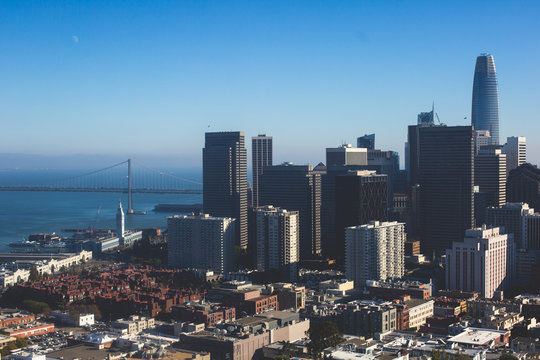 Beautiful super wide-angle aerial view of San Francisco, California, with Bay Bridge, Downtown, Ferry Market, and skyline scenery beyond the city, seen from the observation deck of Coit Tower