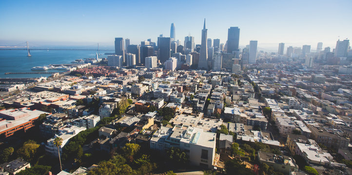 Beautiful super wide-angle aerial view of San Francisco, California, with Bay Bridge, Downtown, Ferry Market, and skyline scenery beyond the city, seen from the observation deck of Coit Tower