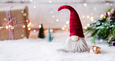 Frohe Weihnachten - Kleiner Wichtel zwischen Geschenken, Schnee und weihnachtlicher Dekoration im Winter  - 234369884