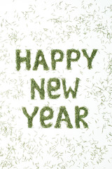 Quote HAPPY NEW YEAR made of spruce needles on white background. Flat lay, top view New Year composition.