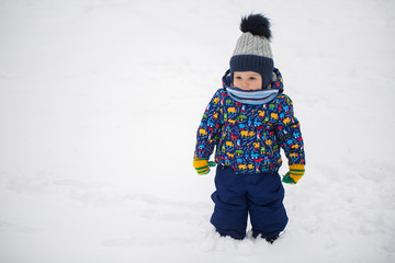 Fototapeta na wymiar Small boy in winter snow.