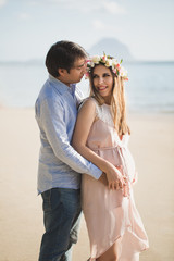 Beautiful pregnant girl and man on the beach
