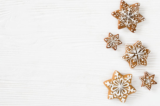 Christmas homemade gingerbread cookies on the white wooden background.