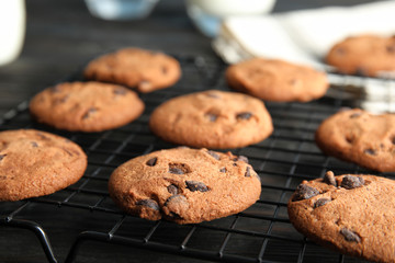 Cooling rack with chocolate chip cookies on wooden background