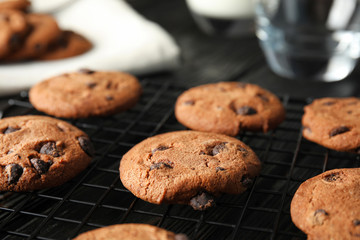 Cooling rack with chocolate chip cookies on wooden background