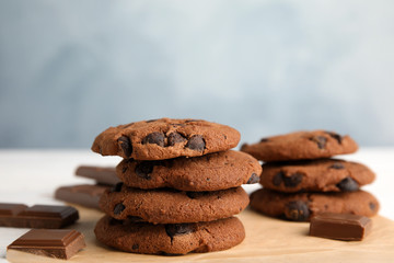 Stack of tasty chocolate chip cookies on parchment, closeup